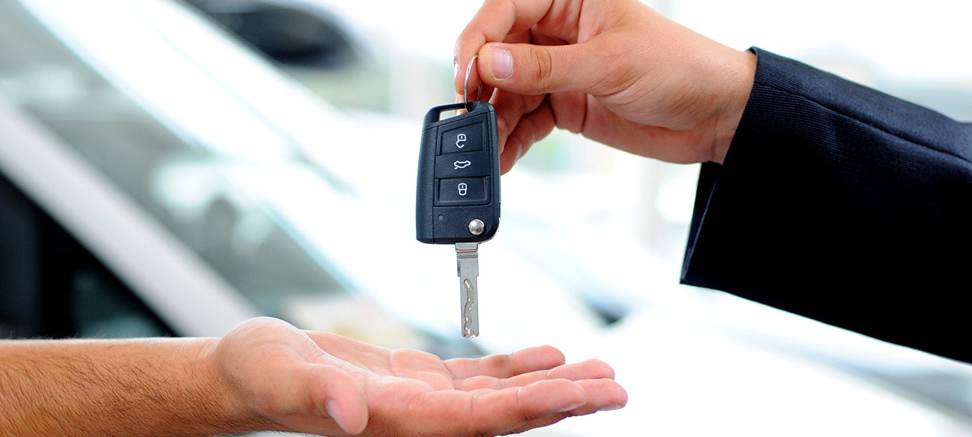 Car salesman handing keys to customer